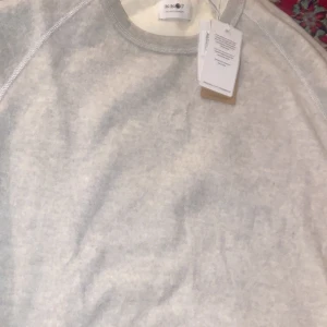 Grå sweatshirt från NN07 100% cotton - Säljer en stilren grå sweatshirt från NN07. Tröjan har en klassisk design med rund hals och långa ärmar. Perfekt för en avslappnad stil. Märket står för kvalitet och hållbarhet. 100 cotton