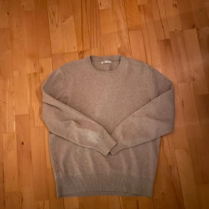 Beige tröja från Zara - Säljer en stilren beige tröja från Zara. Den har en klassisk design med rund hals och långa ärmar. Perfekt för en avslappnad och snygg look. Passar bra till både jeans och chinos.