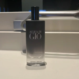 Acqua di Giò Parfum från Giorgio Armani - Säljer en elegant flaska av Acqua di Giò Parfum från Giorgio Armani. Flaskan har en stilren design i svart och grått med en svart kork. Perfekt för den som söker en sofistikerad doft. 10/15 ml ish
