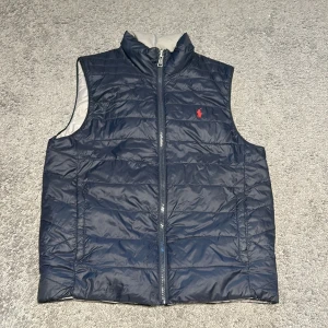 Ralph Lauren väst - Hej, säljer nu en ny snygg vändbar väst från Ralph Lauren i marinblått och grått. Inga defekter eller skador. Storlek är Xs-S. Perfekt nu inför våren. Endast använd 3-5 gånger. Pris kan diskuteras.