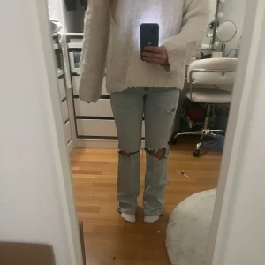 Ljusblåa jeans med hål och slitningar - Midwaist ljusblåa straight/bootcut jeans med hål på knäna och slitningar!🩵 Midjemåttet tvärsöver är ca 37/38cm och innerbenslängden ca 80/81cm!
