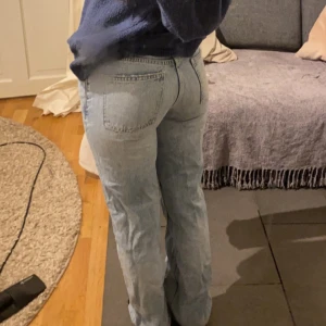 Ljusblå jeans med låg midja - Säljer ett par ljusblå jeans med låg midja och bootcut/straight-stil. De har en klassisk femficksdesign och knappar framtill. Perfekta för en avslappnad look. Köpta från zara.