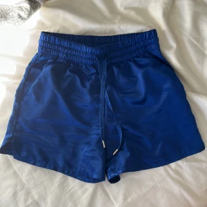 Blå satin shorts - Snygga blå pyjamas shorts med elastisk midja och dragsko. De är i satin och är ett par väldigt sköna satinshorts. Inte använd mycket då de är för små för mig. Kom privat för fler bilder