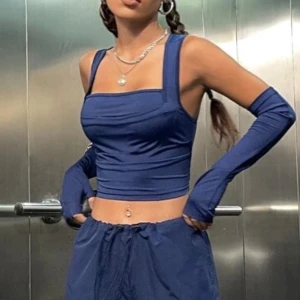 Blå croppad topp med långa handskar - Snygg blå croppad topp med matchande långa handskar. Toppen har breda axelband och en tight passform. Kan säljas med handskar eller utan. 