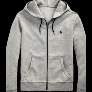 Grå Ralph Lauren ziphoodie - Säljer en stilren grå hoodie från Polo Ralph Lauren med dragkedja och huva. Tröjan har långa ärmar och en liten logotyp på bröstet. Perfekt för en avslappnad stil. PRRISET KAN SJÄLVKLART DISKUTERAS! Den funkar precis som S med!