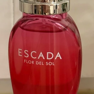 Escada Flor del Sol 30 ml - Säljer en Escada Flor del Sol i en elegant röd flaska med silverfärgat lock. Flaskan rymmer 30 ml. Perfekt för den som älskar söta fruktiga dofter. Endast testsprutad.