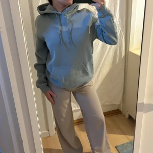 Ljusblå hoodie - Säljer en skön ljusblå hoodie med en stor ficka framtill och justerbar huva. Perfekt för en avslappnad stil. Strlk S (relaxed fit). Säljer då den inte kommer till användning. 
