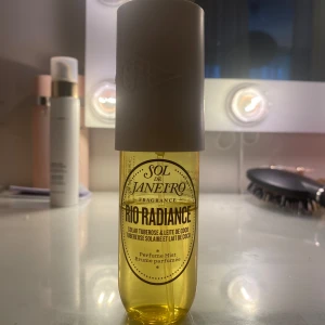 Sol de Janeiro Rio Radiance Perfume Mist - Fräsch och exotisk doft från Sol de Janeiro, Rio Radiance Perfume Mist. Flaskan är gul med en vit kork och har en tropisk doft av solig tuberos och kokosmjölk. Perfekt för att ge en somrig känsla året runt. Lite mindre än halva använt köpt för 300🩷