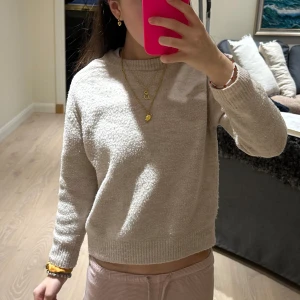 Beige stickad tröja - Mysig beige stickad tröja med långärmad design. Perfekt för kyligare dagar med en enkel och stilren look. Passar bra till både jeans och kjol. Är nopprig och är från Zara men den säljs inte längre! Är lite längre i storlek, om du är någonstans vid 140 cm kan finns det möjlighet att den kanske passar!