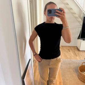 Svart tight topp - Säljer en stilren svart topp med tight passform. Toppen är ärmlös och tillverkad i ett mjukt material som ger en bekväm känsla. Perfekt för en minimalistisk look.