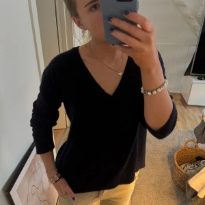 Svart v-ringad kashmir tröja från Filippa K - Säljer en stilren svart v-ringad tröja från Filippa K. Tröjan har långa ärmar och en klassisk passform som passar perfekt till både jeans och kjol. Perfekt för kyligare dagar! 100% Kashmir 