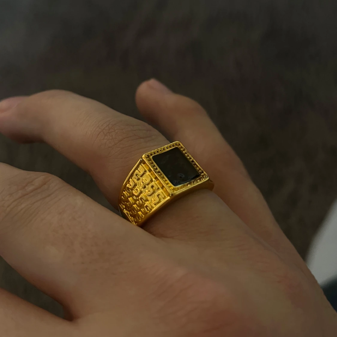 Guldfärgad ring med svart sten