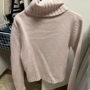 Ljusrosa stickad polotröja - Mysig ljusrosa stickad polotröja med ribbade detaljer vid krage, ärmslut och nederkant. Perfekt för kyliga dagar och ger en stilren look. Passar bra till både jeans och kjol. Prickar kan förekomma på tröjan men inget man tänker på❤️