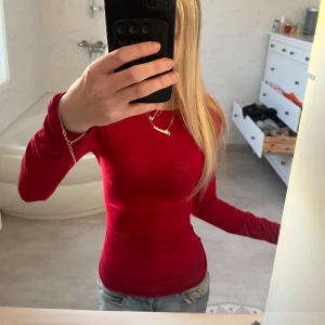 Röd intimissimi  - Säljer en snygg röd långärmad tröja med tight passform. Perfekt för att lägga till en färgklick i garderoben. Passar bra till jeans eller kjol för en stilren look. tröjan kommer ifrån intimissimi och är knappt använd.