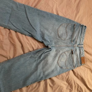 Blå jeans från Lee - Säljer ett par klassiska blå jeans från Lee. De har en normal passform med fem fickor och en dragkedja. 