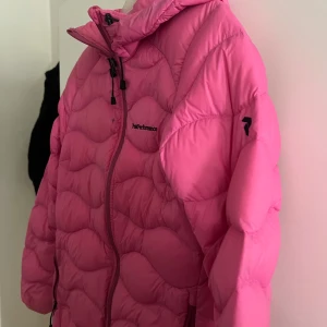Rosa dunjacka från Peak Performance - Säljer en snygg rosa dunjacka från Peak Performance. Jackan har en dragkedja framtill och en justerbar huva. Perfekt för kyliga dagar. I storlek M men liten i storlek! En liten fläck på därav priset men borde inte vara så svårt att få bort. Priset kan diskuteras så hör av er! 