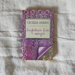Dagboken från i morgon - Säljer boken 'Dagboken från i morgon' av Cecelia Ahern. Den har ett vackert lila omslag med dekorativa mönster och en lockande handling om en dagbok som avslöjar framtiden. Perfekt för dig som älskar magiska och charmiga berättelser.