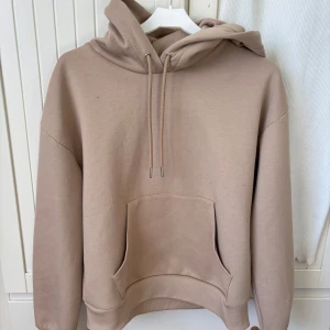 Beige hoodie med känguruficka - Säljer en stilren beige hoodie med känguruficka.