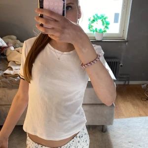 Vit t-shirt från Zara - Säljer den populära tröjan från zara. Jag säljer den eftersom jag tyvär inte andvänder den längre! Den har fina guld detaljer på armarna och är så fin💕Den har en lite fläck längst ner på tröjan som visas på andra bilden