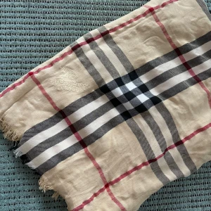 halsduk från Burberry - Hej 👋 den har inga defekter,  men vet inte så mycket mer pga att den är köpt begangnad. Fråga gärna vid funderingar!🙌
