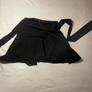Svart kjol från Zara - Snygg svart kjol från Zara med knytning. stilren och passar till allt, pris kan diskuteras!