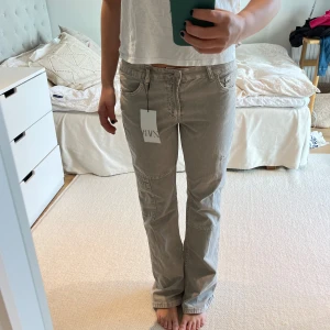 Jeans med cargostil - Säljer dessa såå snygga och coola jeans. De är helt oanvända med lappen kvar. Däremot gick de sönder i en av sömmarna där man sätter bälte när jag testade dem (se bild 3) men väldigt lätt att laga!❤️