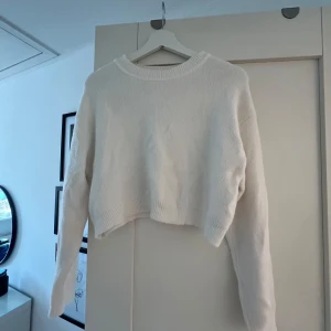 Vit stickad tröja från Zara - Säljer en vit stickad tröja från Zara. Tröjan är croppad med långa ärmar och har en rund halsringning. Perfekt för en stilren och bekväm look! 🩷
