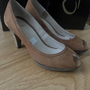 Vintage! Bruna pumps med öppen tå - Snygga bruna pumps i mocka med öppen tå och klack. Perfekta för en elegant look. Klacken har en randig design som ger en extra touch.