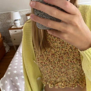 Gul kort kofta med knappar - Superfin ljusgul kort kofta från Kappahl med croppad passform. Stickad i mjukt material, v-ringad och med stora vita knappar framtill. Perfekt att slänga över en topp för en chill och trendig look. Den är inte använd jättemycket men är lite nopprig. Står att den är stl 146/152, men passar mig som har XS-S. Kan köpas med toppen jag har på mig under för 80 kr eller bara koftan för 50 kr (priset går att diskutera). Man kan också bara köpa toppen jag har under för 50 kr, annons finns i min profil❤️