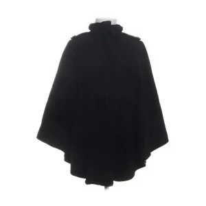 Svart cape från STOCKH LM, stl 38 - Svart cape från STOCKH LM i en snygg, vid modell med hög krage och axelremmar. Jackan är tillverkad i en mjuk blandning av viskos och ull, med foder i polyester. Perfekt för dig som vill ha en stilren och cool look under höst och vinter.
