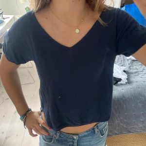 Mörkblå croppad t-shirt med v-ringning - En enkel och stilren mörkblå croppad t-shirt, stickad!!❤️