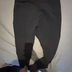 Svarta friluftsbyxor från Haglöfs dam - Svarta friluftsbyxor från Haglöfs för dam, med dragkedjeförsedda fickor och logga på benet. Byxorna är tillverkade i slitstarkt syntetmaterial och har en sportig, funktionell look med normal passform. Perfekta för utomhusaktiviteter och äventyr. Äkta är dom 