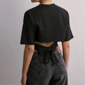 Topp med knyt  - Säljer min fina topp från Nelly som man knyter i ryggen, nyskick! 