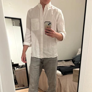 Vit linneskjorta från Zara - Säljer en vit skjorta från Zara i linne. Skjortan har klassisk krage med knappar, lång ärm och en bröstficka. Passformen är normal och material i linnetyg. Använd fyra gånger.