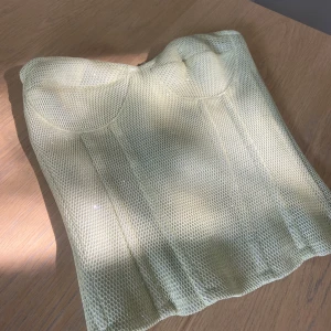 Gul glittrig korsetttopp med dragkedja - Superfin gul korsett med mesh-tyg och glittriga detaljer. 