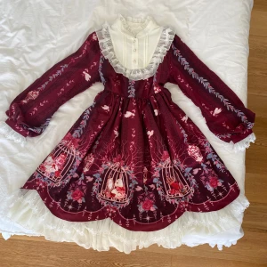 Lolita klänning - Jätte vacker lolita klänning i röd med fina detaljer. Perfekt för till exempel julafton ❤️Har ett snöre på baksidan för att dra åt i midjan, och en dragkedja på sidan. säljer då den tyvärr var för liten för mig. Rosetten på kragen på sista bilden ingår inte. 