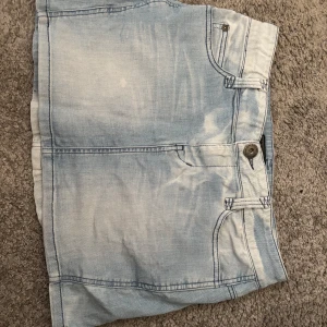Ljusblå jeanskjol från Only - Säljer en ljusblå jeanskjol från Only med klassisk femficksdesign, knapp och dragkedja framtill samt bälteshällor. Kjolen har en snygg tvättad look och raka linjer, perfekt för dig som gillar denim och vill ha en chill stil. Pris kan diskuteras 💕