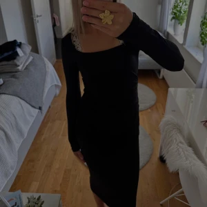 Svart långklänning från Gina Tricot - Svart långklänning från Gina Tricot i mjuk bomull. Klänningen har lång ärm, djup ringning och figurnära passform. Enkel och stilren design som passar perfekt när du vill känna dig extra snygg!