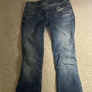 LTB bootcut jeans blå low rise 27/30 - Snygga blå bootcut jeans från LTB med låg midja och slitna detaljer. De är en av bältesögglorma som gått av, man kan klippa av eller sy fast igen men jag har inte fixat den än. Säljer pågrund av att jeansen inte passar längre. Kom privat för mer bilder. 💕
