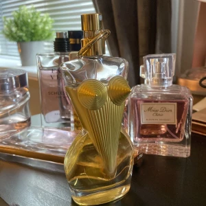 Jean Paul Gaultier Classique parfym - Ikonisk parfymflaska från Jean Paul Gaultier formad som en kvinnokropp med guldiga detaljer och konformad byst. Flaskan är genomskinlig med ljusgul vätska inuti och har en unik, konstnärlig design som verkligen sticker ut på parfymhyllan. 50ml. Nästan full.