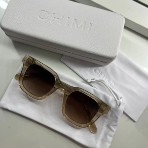 Chimi solglasögon Ecru fyrkantiga - Snygga solglasögon från Chimi i modellen Ecru med transparent beige ram och bruna tonade glas. Solglasögonen är använda ett fåtal gånger och har varit väl omhändertagna. Glaset har inte en ända repa, däremot har den nån repa vid ”bron” men syns inte alls. Självklart medföljer originalfodral och putsduk! Skriv vid fler frågor!!💓