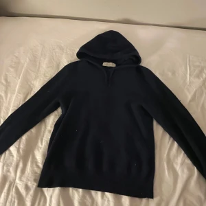 Mörkblå hoodie - Säljer en stilren mörkblå kashmir hoodie från sayless. Perfekt för kyligare dagar med sin mjuka och bekväma passform. Huvan ger extra värme och stil. Passar bra till både jeans och joggers. 100% Kashmir köpt på sayless. Nypris 900 pris går att diskutera