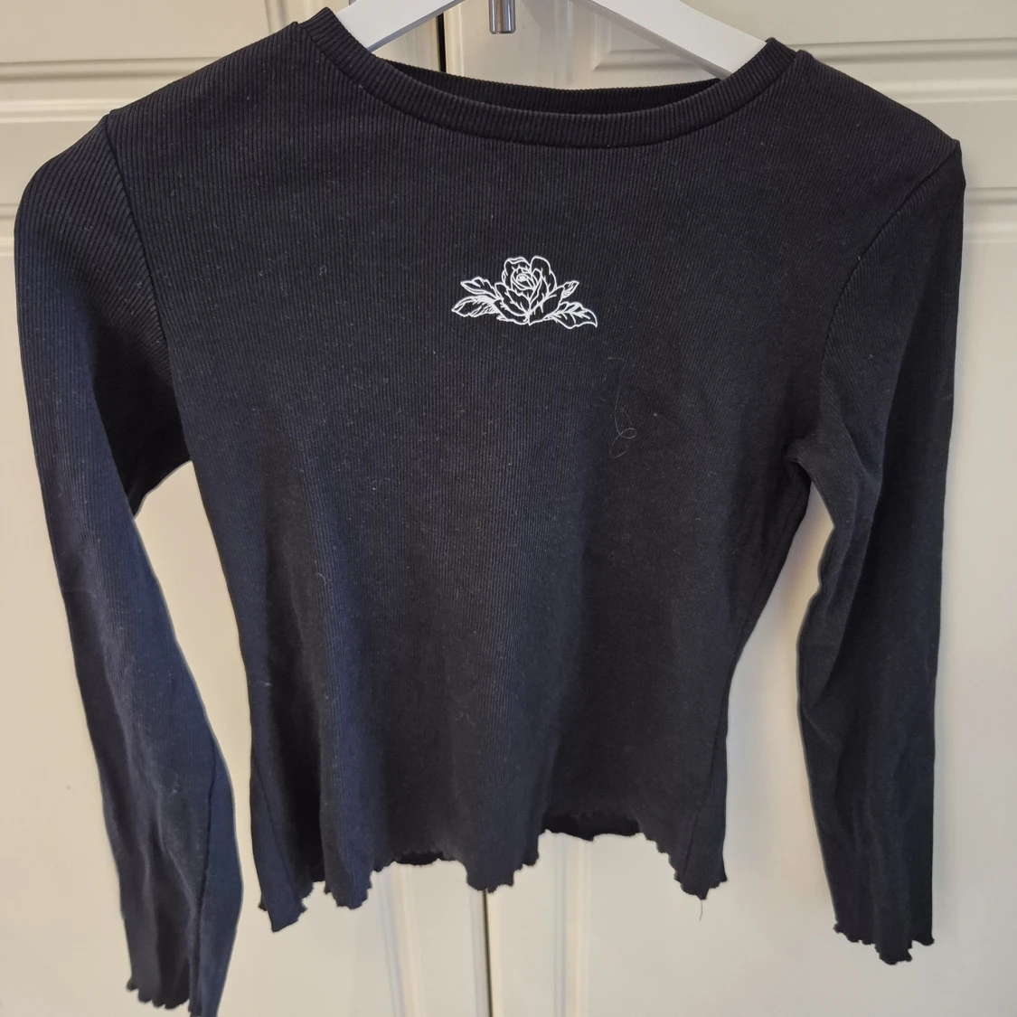 Svart långärmad topp med broderad ros