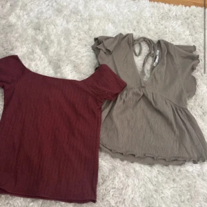 Två toppar: vinröd offshoulder & beige knyt - Säljer två snygga toppar! En vinröd offshoulder topp med kort ärm och ribbad struktur. Den andra är beige med volangärm, djup v-ringning och knyt i nacken, samt lätt volangkant nedtill. Båda i mjukt, stretchigt material – perfekta för att lyfta din outfit.