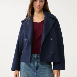 Mörkblå kappa från Stradivarius - Säljer en snygg mörkblå kappa från Stradivarius. Jackan had dubbelknäppning, bred krage och raka ärmar. Tillverkad i ullblandning som ger en clean och stilren look. Perfekt för dig som gillar klassiska vibbar med modern twist. Orginalpris 599kr💙