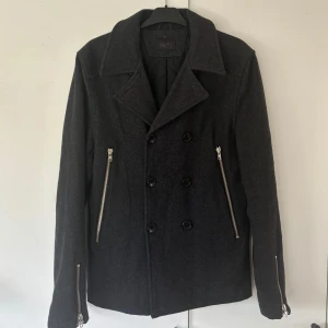 Tiger of Sweden skepparjacka - Brutalt snygg och unik dubbelknäppt mörkgrå Tiger of Sweden jacka i storlek M säljes. Nypris på ca 4000 och i denna känner sticker du ut perfekt för dig som inte vill vara så mainstream. Inga som helst tecken på användning då den är helt ny och i storlek M. Äkta skandinaviskt konstverk för svenskt mode! Tveka inte vid minsta fråga eller fundering och pris ej hugget i sten😃