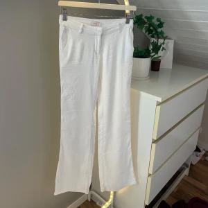 Vita linnebyxor från Nelly, strl 32 - Snygga vita linnebyxor från Nelly i storlek 32. Byxorna har raka ben, normal passform och låg midja. Slut sålda online, använd endast 1-2 gånger!