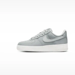 Nike Air Force 1 grå sneakers - Snygga Nike Air Force 1 sneakers i en ljusgrå färg med klassisk vit sula. Skorna har rund tå, snörning och är tillverkade i skinn. Perfekta för dig som gillar stilrena och tidlösa sneakers med ikonisk design. Köpta på Nikes officiella hemsida. Ett släpp och säljs inte fler. Nypris: 1599kr. Använda men i bra skick, rengjorda och utan skador.