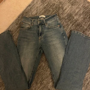 Blåa Perfect Jeans bootcut 34 - Snygga blå jeans i storlek 34. Modellen har klassisk femficksdesign, normal midja och bootcut-ben.