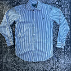 Randig skjorta från Polo Ralph Lauren - Väldigt stilig skjorta I Ralph Lauren. Superfin i mycket gott skick. Storlek 16, motsvarar S-XS. 